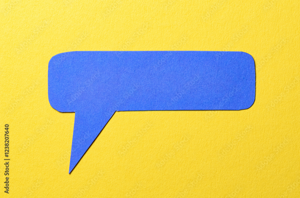 Poster Blue cut out blank paper speech bubble of rectangular shape and rounded corners with copy space for text on yellow background, flat lay top view conceptual backdrop