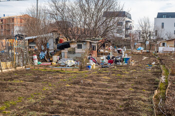 Naklejka premium Abandoned places and garbage on the edge of the city near new residential areas, soil and water pollution affecting local ecosystems