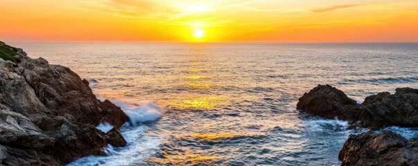 Obraz premium Sunset over ocean waves nature idea. Breathtaking sunset over the ocean, illuminating the tranquil waters and rocky shore.