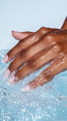 Fototapeta premium Close up of a hand with water droplets, immersed in clear blue water with ripples, showcasing freshness and hydration