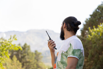 Faceless man holding two-way radio for hiking. Walkie-talkie in hand