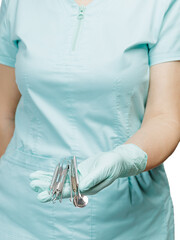 Set of metal dental instruments for teeth dental care in hands.