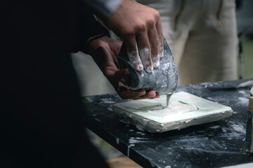 Stuckateuer gießt in eine Formschale