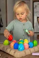 Obraz premium Colorful Easter egg decorating activity at home during spring holiday with a child