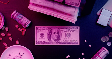 The calculating machine counts hundred dollar bills. Benjamin Franklin winks from a bill lying on the table. View from above. The Mafia's desktop