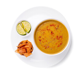 Enjoying a warm bowl of comforting soup with lime and crispy chips served on a white plate