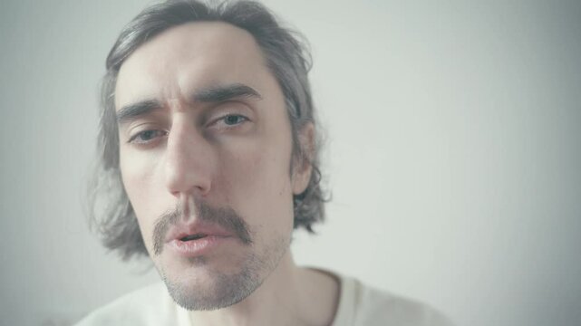 Cheerful Slav Man Approvingly Nods Happy man with long hair and a moustache expresses agreement with a scenic backdrop while sharing a lighthearted moment