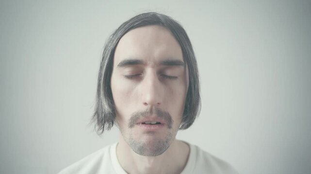 Weird Slavic Man Staring Scenic Young Slavic man with a mustache and long hair gazes oddly into the camera against a picturesque background