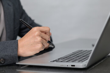 Professional Hand Writing on Laptop with Pen for Business Tasks