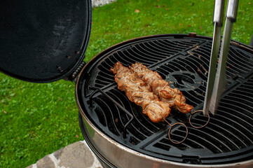 Tasty chicken legs and wings on the grill with fire flames