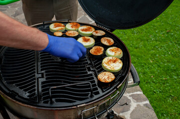 The cook prepares grilled vegetables, grilled zucchini, barbecue. Photo of food.