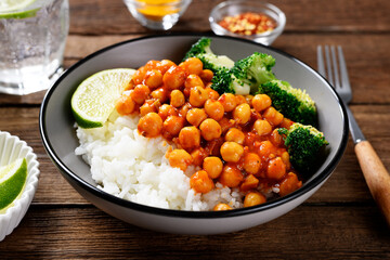 Chickpea curry with basmati rice and broccoli on wooden background