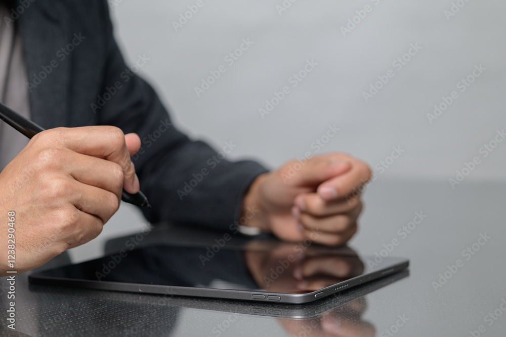 Poster person using digital tablet with stylus in professional setting