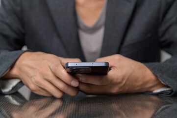 Close-Up of Person Holding Smartphone in Black Suit Coat