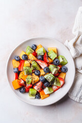 Fruit salad with kiwi, persimmon, berries and poppy seed dressing.