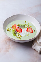 Green matcha yogurt with berries and pistachio. Vegan breakfast concept.