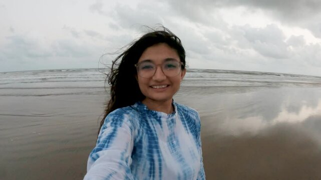 4k Selfie video of Indian girl enjoying vacation on tropical beach at Mandvi, Gujarat, India. Content creator, influencer or happy girl taking holiday pictures to post on social network.
