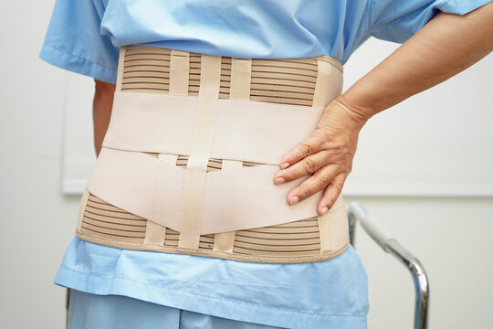 Asian woman wearing lumbar support pain back and use walker in hospital.