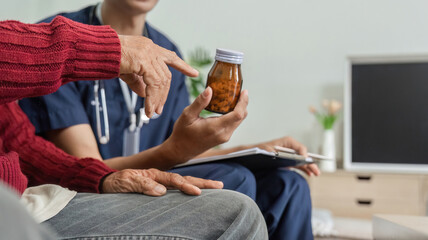 Elderly patient discussing medication with nurse in a home setting.