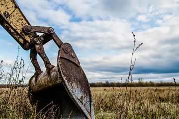 Close-up view of an excavator bucket in a field