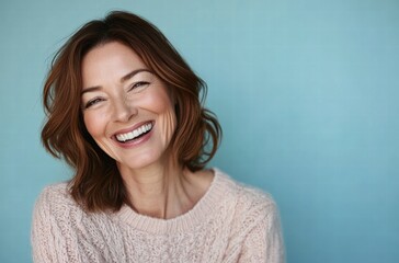A woman with a smile on her face is wearing a pink sweater