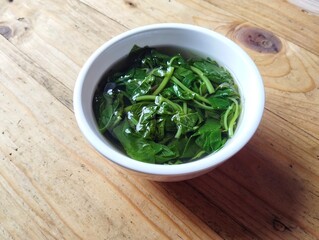 Spinach soup in bowl on wooden table background with high angle view. Vegetarian cuisine