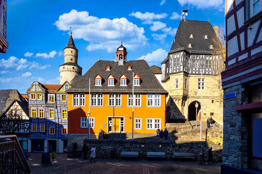 Tourists enjoying a sunny winter day in the charming town of Idstein, hesse, germany, admiring its colorful half-timbered houses