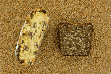 Kinds of baking. Sourdough Multigrain Bread with sunflower seeds. Pastries with raisins and candied fruits. Wheat background. Top view.
