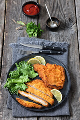 Pork Milanese with lettuce and lemon on a plate