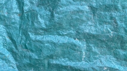 Textured blue tarp surface showing creases and color variations