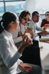A diverse group of business colleagues actively engaging in discussion, analyzing documents, and brainstorming ideas in a bright and modern office environment, symbolizing teamwork and collaboration.