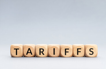 TARIFFS word on wooden blocks isolated on gray background. Copy space