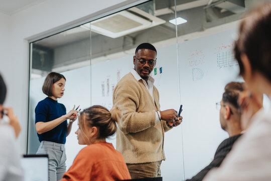 A diverse group of colleagues engaged in a creative brainstorming session in a modern office setting. The team is discussing ideas and strategies, fostering a collaborative and productive environment.