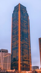 Fototapeta premium Illuminated Modern Skyscraper at Dusk Cityscape View Urban Architecture