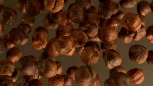 Whole hazelnuts exploding, close-up, wide super macro shot with camera movement and rotation. Filmed on high speed cinematic camera at 1000 fps.