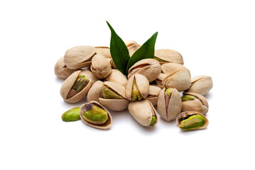 pistachio nuts with green leaves on white background