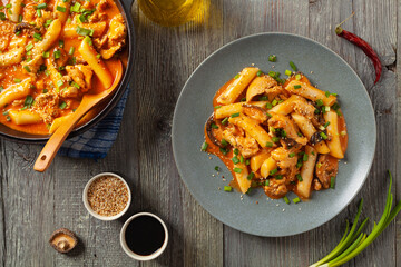 Traditional Korean Tteokbokki rice noodles with chicken, vegetables and shitake mushrooms. Prepared in a pan.