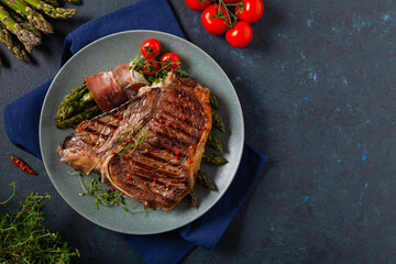 Grilled, medium-baked t-bone beef steak. Served with asparagus.