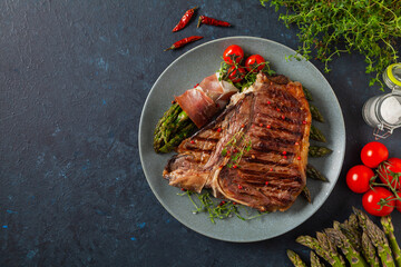 Grilled, medium-baked t-bone beef steak. Served with asparagus.