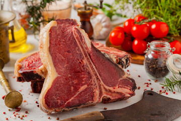 Raw t bone steak, with herbs. Stone bright background