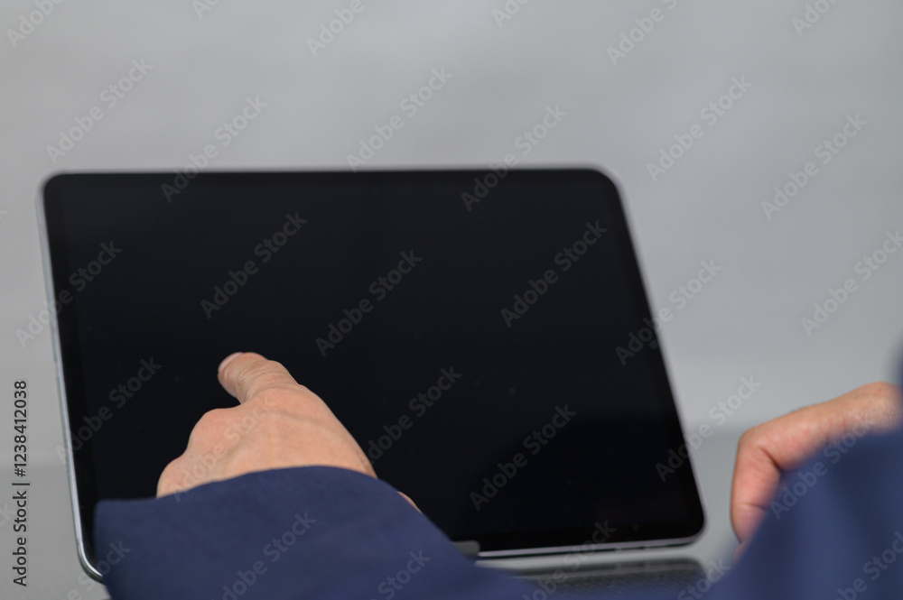 Poster person interacting with a touchscreen tablet displaying blank screen