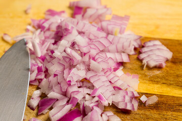 diced red onion on a wooden chopping board