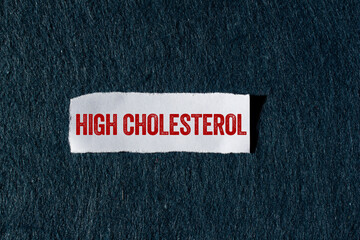 High cholesterol message written on ripped torn paper piece with gray background. Conceptual high...