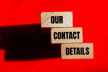 Our contact details message written on wooden blocks on red background. Conceptual our contact details symbol. Copy space.