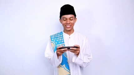 handsome young muslim asian expression smiling gesture playing mobile phone with isolated white background