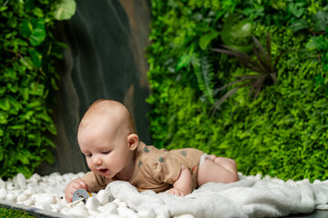 Baby exploring on soft white pebbles. A baby is crawling on a soft surface surrounded by white...