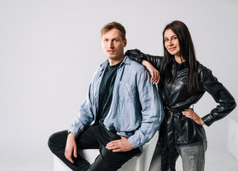 Young adults in a studio. Two young adults are posing together in a contemporary studio with minimalist background and casual attire.