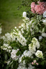 Wedding ceremony. Very beautiful and stylish wedding arch, decorated with various fresh flowers, standing in the garden. Wedding day. Fresh flowers decorations, Peony weddng.