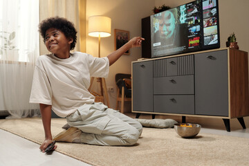 Smiling Male Sitting on Floor Watching Television