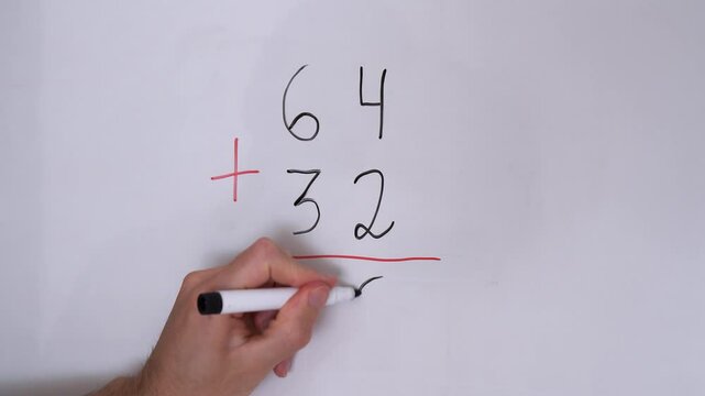 Performing simple math with two-digit sums on a white board.